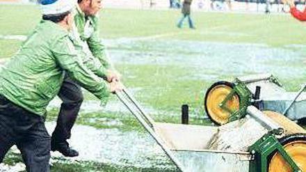 Morast statt Rasen. Mit Walzen versuchen Stadionhelfer 1974 in Frankfurt vor dem WM-Spiel Deutschland den Platz zu entwässern. Foto: dpa