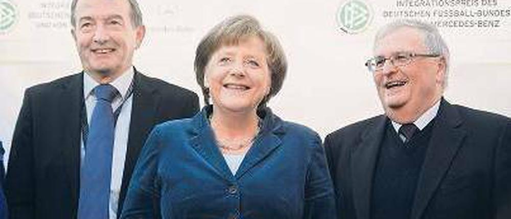 Bald-Präsident, Kanzlerin, Noch-Präsident. Theo Zwanziger (r.) und sein Kollege Wolfgang Niersbach nehmen Angela Merkel gern in ihre Mitte. Foto: dpa