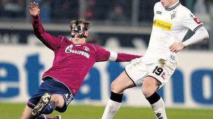 Zorro kommt zu spät. Auch der Schalker Benedikt Höwedes (l.) konnte Mike Hanke und Gladbach nicht stoppen. Foto: dpa