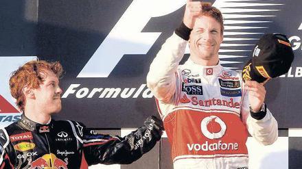 Ausnahmsweise darfst du mal. Sebastian Vettel (links) gratuliert Jenson Button zu dessen Sieg in Melbourne. Foto: dpa