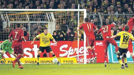 Mit dem Rücken zum Tor. Robert Lewandowski (Mitte) braucht gar nicht hinzusehen, bevor er mit der Hacke das Siegtor für Borussia Dortmund erzielt. Foto: Reuters