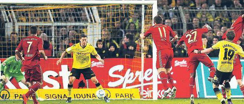 Mit dem Rücken zum Tor. Robert Lewandowski (Mitte) braucht gar nicht hinzusehen, bevor er mit der Hacke das Siegtor für Borussia Dortmund erzielt. Foto: Reuters