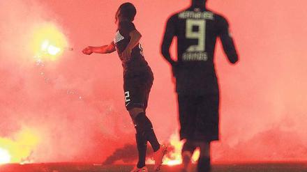Im Fadenkreuz. In Düsseldorf warfen Hertha-Anhänger Bengalo-Fackeln, die bis zu 1600 Grad heiß brennen, auf die eigenen Spieler, wie hier Ronny (links). Foto: Reuters