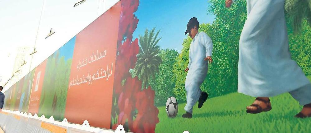 Dribbling unter Palmen. In Katars Hauptstadt Doha werben Plakate für die Fußball-WM 2022. Stadien und Fans gibt es kaum.