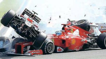 Ende in Kurve eins. Fernando Alonsos Ferrari (rechts) wird direkt nach dem Start von Romain Grosjeans Lotus torpediert. Foto: dapd