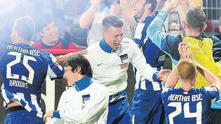 Wie im Rausch. Einige Hertha-Spieler bejubeln in der Kurve ihrer Fans den Sieg über Union. Foto: dpa