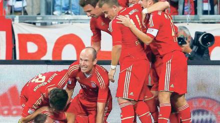 Ein Bayer am Boden. Und das findet Franck Ribéry (unten) auch gut, schließlich hat Bastian Schweinsteiger (Zweiter von rechts) gerade das 1:0 erzielt. Foto: Reuters
