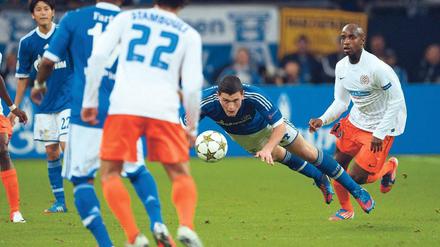 Mit höchstem Einsatz. Schalkes Verteidiger Kyriakos Papadopoulos (blau) und Montpelliers Angreifer Souleymane Camara kämpfen um den Ball. Foto: AFP
