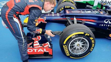 Hier eist der Chef noch selbst. Weil nach der Qualifikation kein Mechaniker das Auto anfassen darf, kühlte Sebastian Vettel die Bremsscheiben seines Autos selbst herunter. Foto: dpa