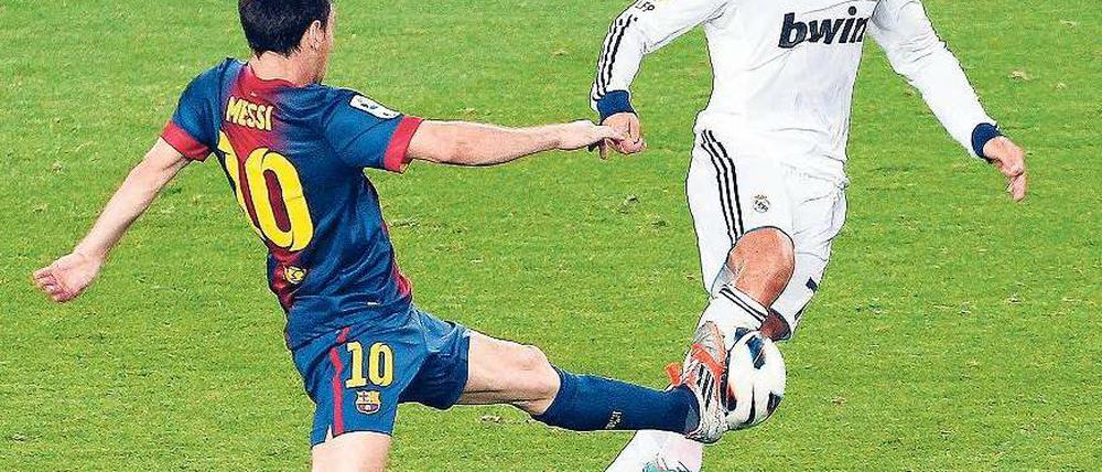 Zauberer am Werk. Messi (l.) und Ronaldo buhlen um die Gunst des Balls. Foto: dpa
