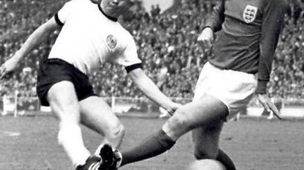 Souvenirjäger. Helmut Haller (l.) trifft an Bobby Moore vorbei. Das WM-Finale 1966 verlor er, den Ball aber behielt er. Foto: dpa