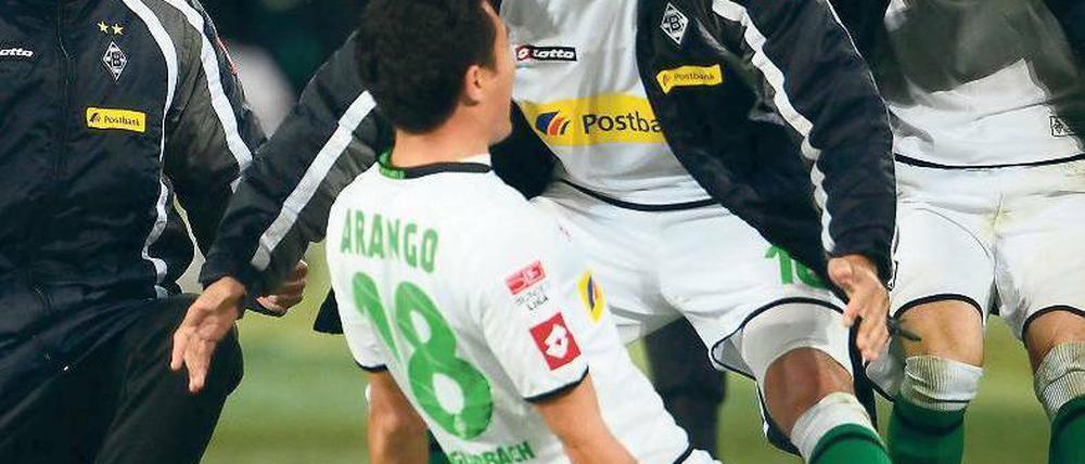 Rutsch ins Glück. Nach seinem Freistoßtor zum 3:2 für Borussia Mönchengladbach lässt sich Juan Arango von seinen Kollegen feiern. Der Venezolaner war an allen drei Treffern beteiligt. Foto: dpa