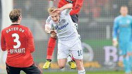 Bayer obenauf. Ömer Toprak fliegt, für Schalkes Lewis Holtby (in weiß) ist das zu hoch. Foto: dapd