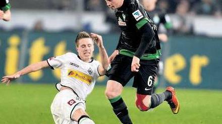 Langes Bein muss auch mal sein. Mönchengladbachs Patrick Hermann (links) im Duell mit Bremens Kevin De Bruyne. Foto: dpa
