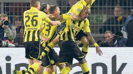 Siegtorschütze im Würgegriff. Dortmunds Spieler bedanken sich auf nicht ganz zärtliche Weise bei Felipe Santana, der mit seinem Tor in der dritten Minute der Nachspielzeit eine denkwürdige Begegnung entschieden hat. Foto: AFP