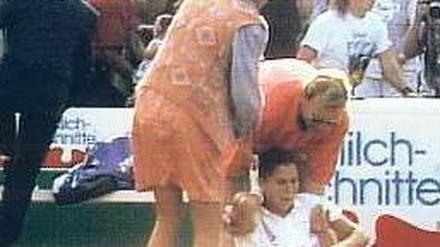 Hamburg, 30. April 1993. Verletzt von einem Messerstich greift sich Monica Seles auf dem Platz an den Rücken, im Hintergrund wird der Attentäter überwältigt. Foto: p-a/dpa