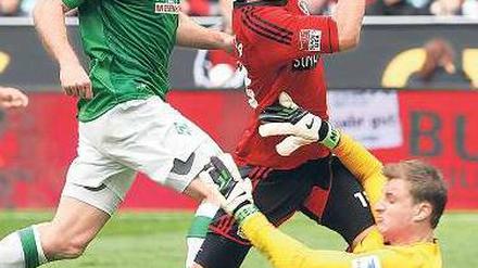 Vollkontakt. Leverkusens Stürmer Sam (Mitte) stürzt über Werders Torhüter Mielitz (rechts). Gleich gibt es Elfmeter. Foto: dpa