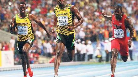 Ende eines Arbeitstags. Usain Bolt schien der Sieg diesmal mehr Mühe zu bereiten als sonst. Links neben ihm der Viertplatzierte Kemar Bailey-Cole, rechts der Zweitplatzierte Justin Gatlin. Foto: dpa