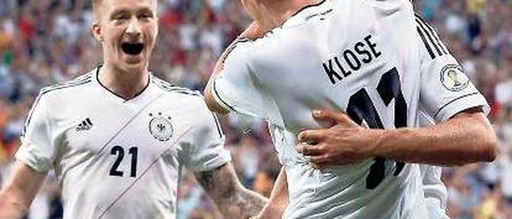 Das Tor zum Jubiläum. Miroslav Klose feiert seinen Treffer, Thomas Müller (r.) ist erster Gratulant vor Marco Reus (l.). Foto: Reuters