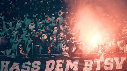 Geisterspiel. Weiß vermummt zündeln Chaoten im Block von Hannover 96 und schmähen Eintracht Braunschweig mit Plakaten.  Foto: dpa