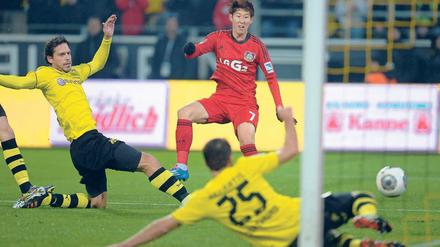 Südkoreanisches Siegtor. Heung Min Son trifft für Leverkusen, Manuel Friedrich (l.) und Sokratis strecken sich vergeblich.