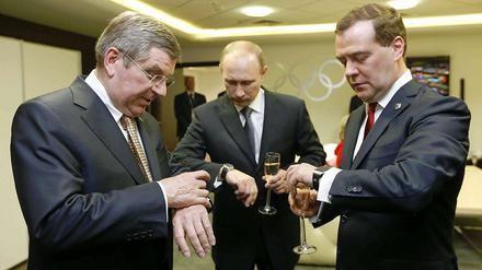 Uhrenvergleich. IOC-Präsident Thomas Bach mit Wladimir Putin und Dmitry Medvedev (von links).