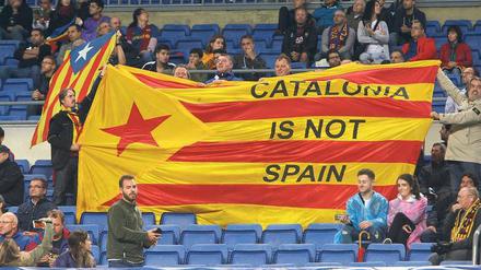 Auf der Tribüne beim FC Barcelona. Fans des 24-maligen spanischen Fußballmeisters halten eine Fahne mit der Aufschrift „Katalonien ist nicht Spanien“ hoch. 
