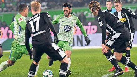 Einen Weg gibt es immer. Wolfsburgs Yunus Malli (Mitte) beschäftigt seine Gladbacher Gegenspieler. 
