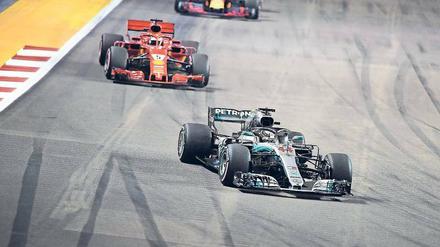 Er fährt nur hinterher. Sebastian Vettel liegt sechs Rennen vor Schluss schon 40 Punkte hinter dem Führenden Lewis Hamilton (r.). In Singapur wählte sein Ferrari-Team die falsche Reifenstrategie, so dass er am Ende nur Dritter wurde. 