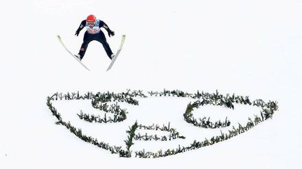 Hoch und weit. Markus Eisenbichler fliegt an der Großen Olympiaschanze über das Logo des SC Partenkirchen. 