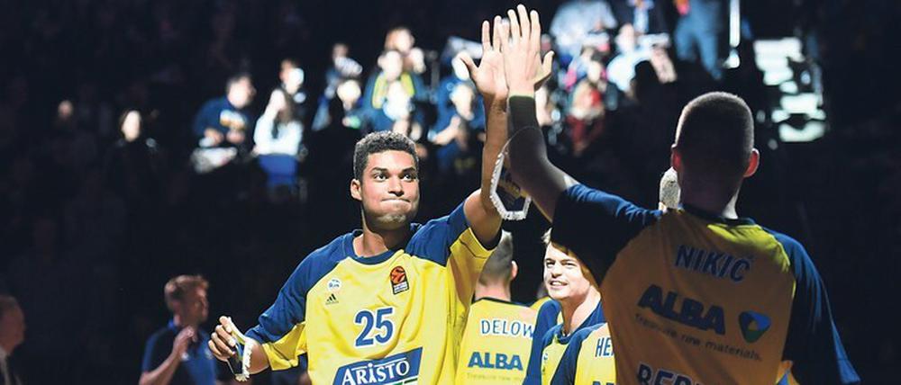 Alba Berlins Basketballer Kenneth Ogbe und seine Teamkollegen zelebrieren das High Five beim Einlaufen.