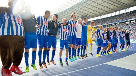 Die Hertha-Spieler hüpfen auf der Laufbahn vor der Fankurve.