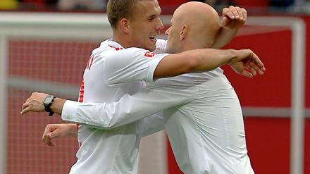 Matchwinner Lukas Podolski (l.) umarmte nach dem rheinischen Derby seinen Trainer Stale Solbakken, der nach der Kritik der letzten Wochen nun erstmal in Ruhe weiterarbeiten kann.