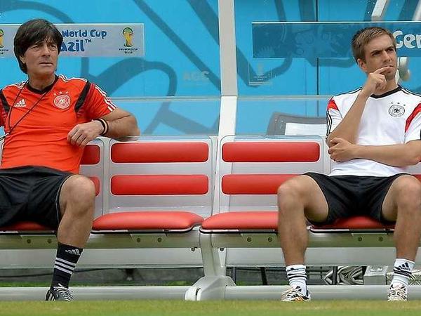 Bundestrainer Joachim Löw und Kapitän Philipp Lahm sitzen beim Training bei der Fußball-WM 2014 in Brasilien auf der Trainerbank und pausieren.