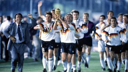 Gruppenbild mit Pokal. Lothar Matthäus und Rudi Völler (v.l.) feierten vor 30 Jahren den dritten WM-Titel der deutschen Nationalmannschaft.