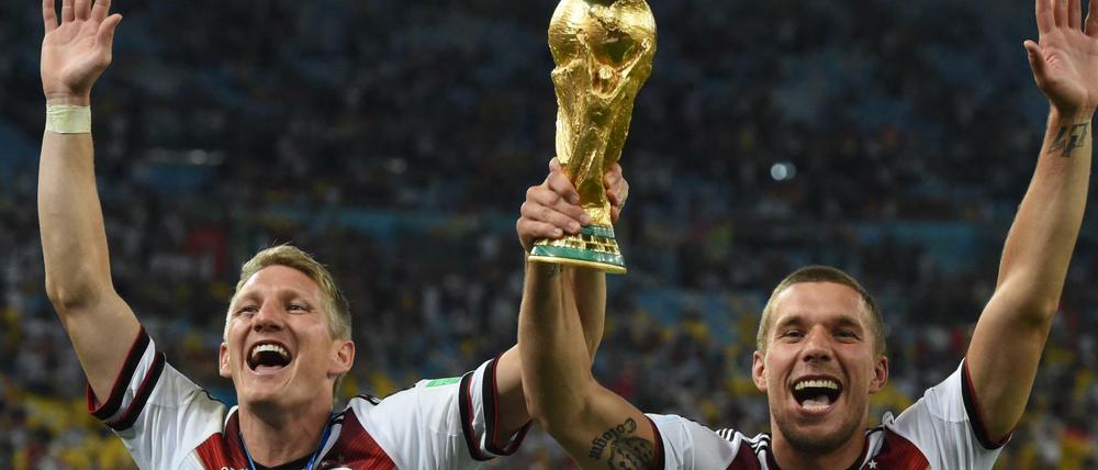 Bastian Schweinsteiger und Lukas Podolski mit dem WM-Pokal nach dem Finale in Rio. 