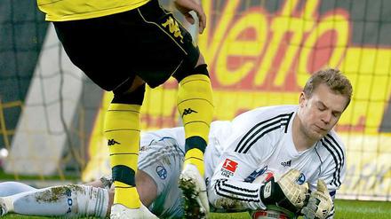 Schalkes Torhüter Manuel Neuer sichert den Ball vor Dortmunds heranstürmendem Lucas Barrios.