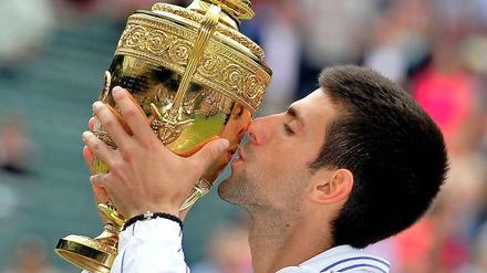 Novak Djokovic küsst erstmal den Siegerpokal von Wimbledon.