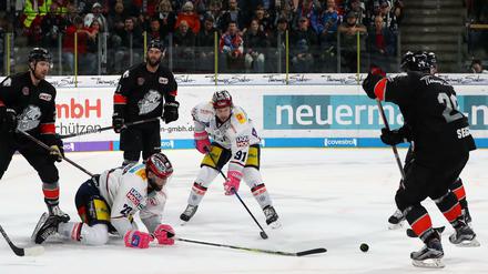 Die Nürnberger Andreas Jenike (r), Oliver Mebus (l) und Philippe Dupuis (hinten M) kämpfen mit den Berlinern Thomas Oppenheimer (M., l) und Mark Olver um den Puck.