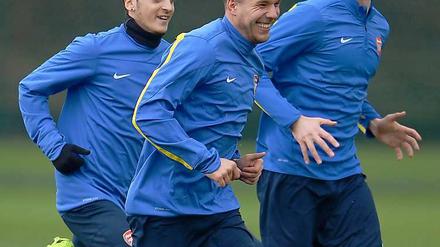 Ein Team. Lukas Podolski (Mitte) soll auch weiterhin mit seinen Landsleuten Mesut Özil und Per Mertesacker für den FC Arsenal spielen. 
