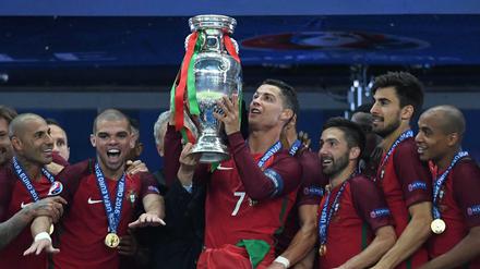 Portugals Stürmer Cristiano Ronaldo mit der Trophäe, umringt von seinen Teamkollegen.