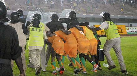 Kopf runter in Dakar. Nach ihrem 2:0-Sieg gegen den Senegal verlassen die Nationalspieler der Elfenbeinküste unter Polizeischutz den Platz.
