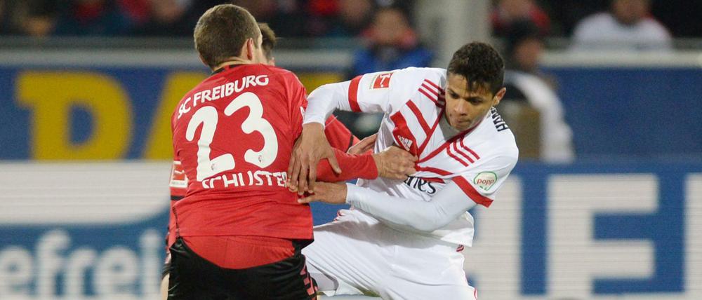 Julian Schuster (l) von Freiburg und Douglas Santos (r) von Hamburg kämpfen um den Ball.