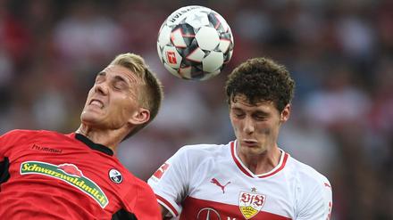 Nils Petersen (l) von Freiburg kämpft mit Benjamin Pavard (r) von Stuttgart um den Ball. 
