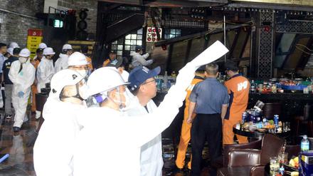 Feuerwehrmänner und Sicherheitskräfte untersuchen den Nachtclub in Gwangju nach dem Unglück.