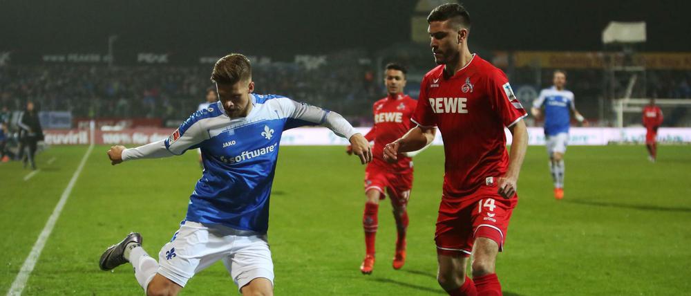 Der Darmstädter Tobias Kempe (l.) und der Kölner Jonas Hector versuchen an den Ball zu kommen. 