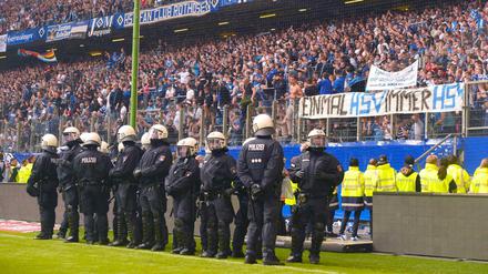 Policemen stand on the pitch after the German first division Bundesliga football match Hamburger SV vs Borussia Moenchengladbach, in Hamburg, nothern Germany, on May 12, 2018. / AFP PHOTO / Patrik STOLLARZ / RESTRICTIONS: DURING MATCH TIME: DFL RULES TO LIMIT THE ONLINE USAGE TO 15 PICTURES PER MATCH AND FORBID IMAGE SEQUENCES TO SIMULATE VIDEO. == RESTRICTED TO EDITORIAL USE == FOR FURTHER QUERIES PLEASE CONTACT DFL DIRECTLY AT + 49 69 650050