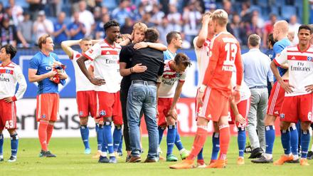Hamburg&amp;apos;s German head coach Christian Titz stands with the players on the pitch after the German first division Bundesliga football match Hamburger SV vs Borussia Moenchengladbach in Hamburg, northern Germany, on May 12, 2018. / AFP PHOTO / Patrik STOLLARZ / RESTRICTIONS: DURING MATCH TIME: DFL RULES TO LIMIT THE ONLINE USAGE TO 15 PICTURES PER MATCH AND FORBID IMAGE SEQUENCES TO SIMULATE VIDEO. == RESTRICTED TO EDITORIAL USE == FOR FURTHER QUERIES PLEASE CONTACT DFL DIRECTLY AT + 49 69 650050