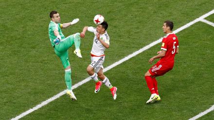 Russlands Torhüter Igor Akinfejew verpasst vor dem Mexikaner Hirving Lozano im entscheidenden Moment den Ball.