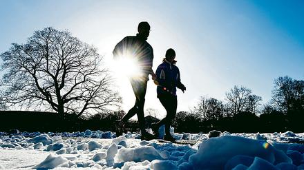 Jogger im Schnee. Manchmal tut es gut, auch mal beim Laufen eine Pause einzulegen.